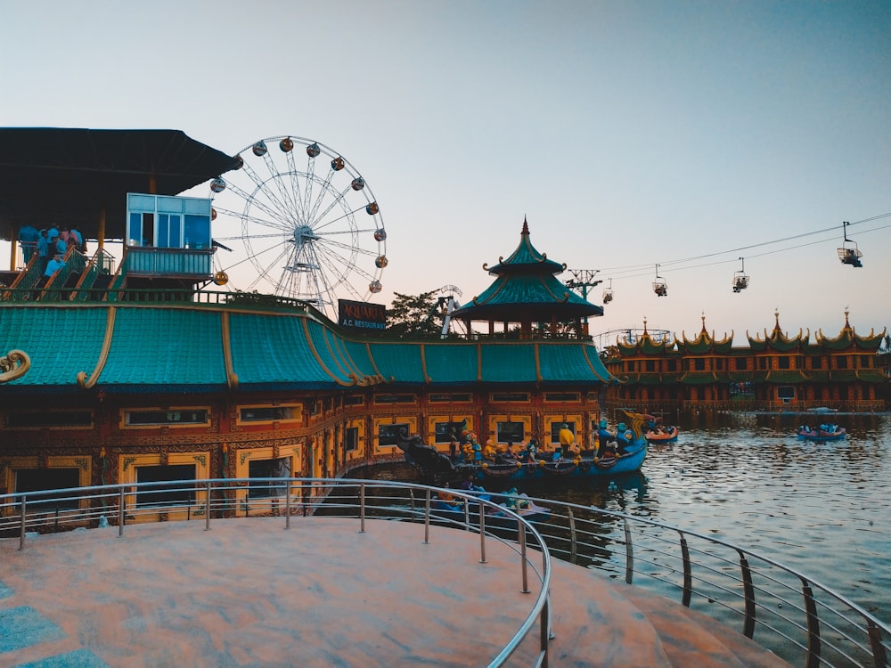 blue and orange house near amusement park beside body of water during daytime