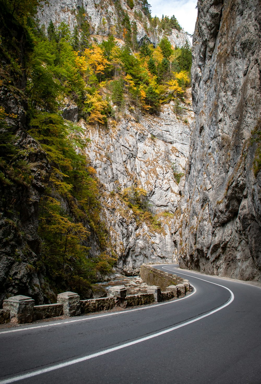 Carretera asfaltada rodeada de montañas rocosas