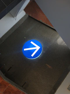 Close-up of a clear, blue circular traffic sign indicating a mandatory direction.