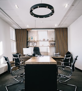 brown and black office table and four black cantilever chairs