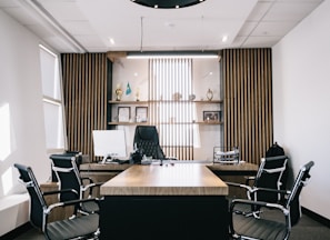 brown and black office table and four black cantilever chairs