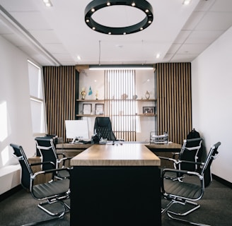 brown and black office table and four black cantilever chairs