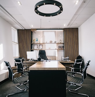 brown and black office table and four black cantilever chairs