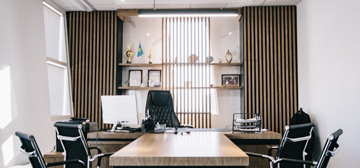 brown and black office table and four black cantilever chairs