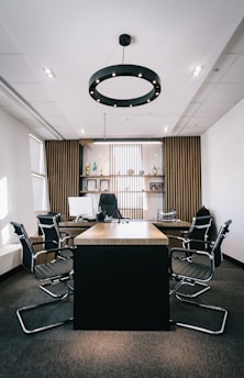 Black and white photo of a sleek, modern office with sharp grid lines and a large wooden conference table.