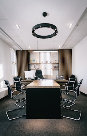 An elegant black and gold themed office space with a sleek conference table and subtle gold accents reflecting professionalism and luxury.