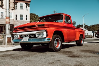 classic red GMC single cab pick up truck on road