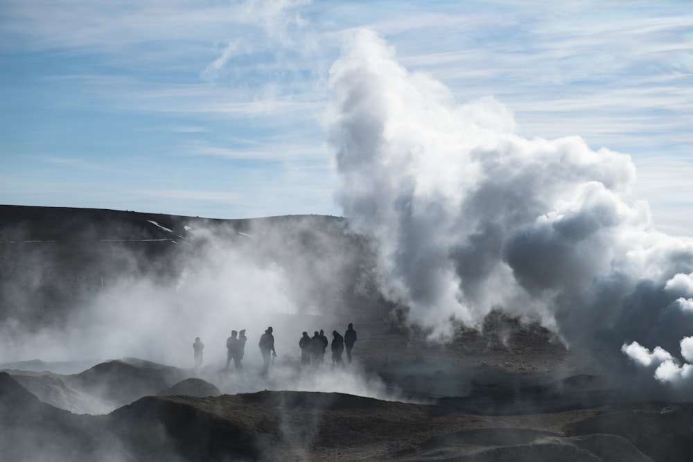 a group of people standing around a geyser