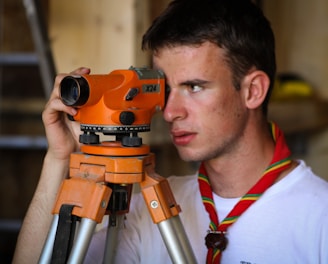 man standing beside orange leveler