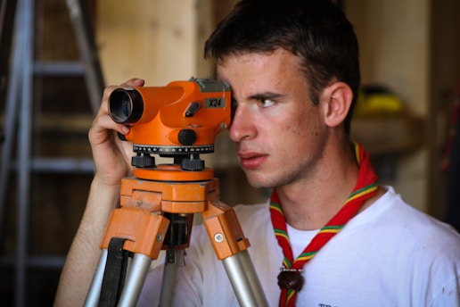 man standing beside orange leveler