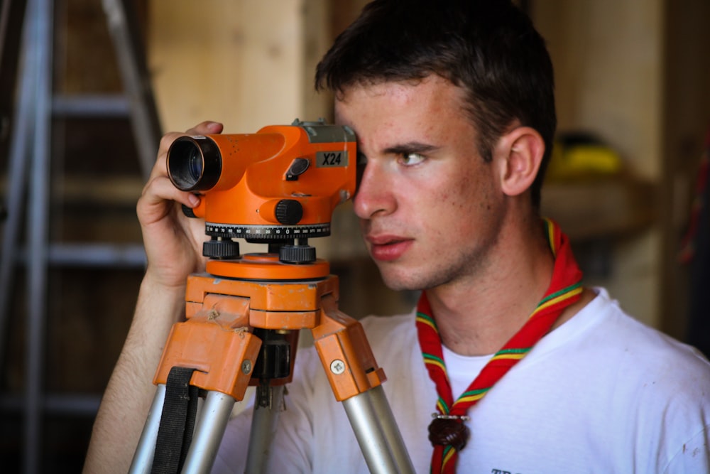 man standing beside orange leveler