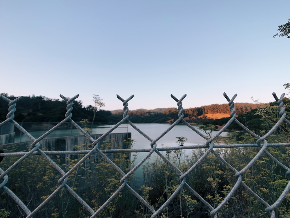 a view of a river through a chain link fence