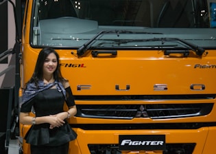 Close-up of a customer happily shaking hands with a sales representative beside an Isuzu truck.