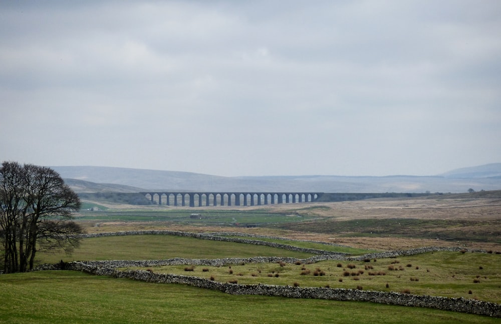 brown concrete bridge under cloudy sky