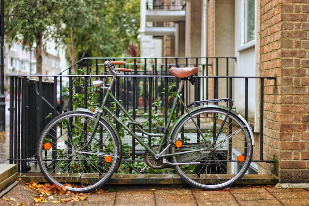 green and black bike parking near black railings