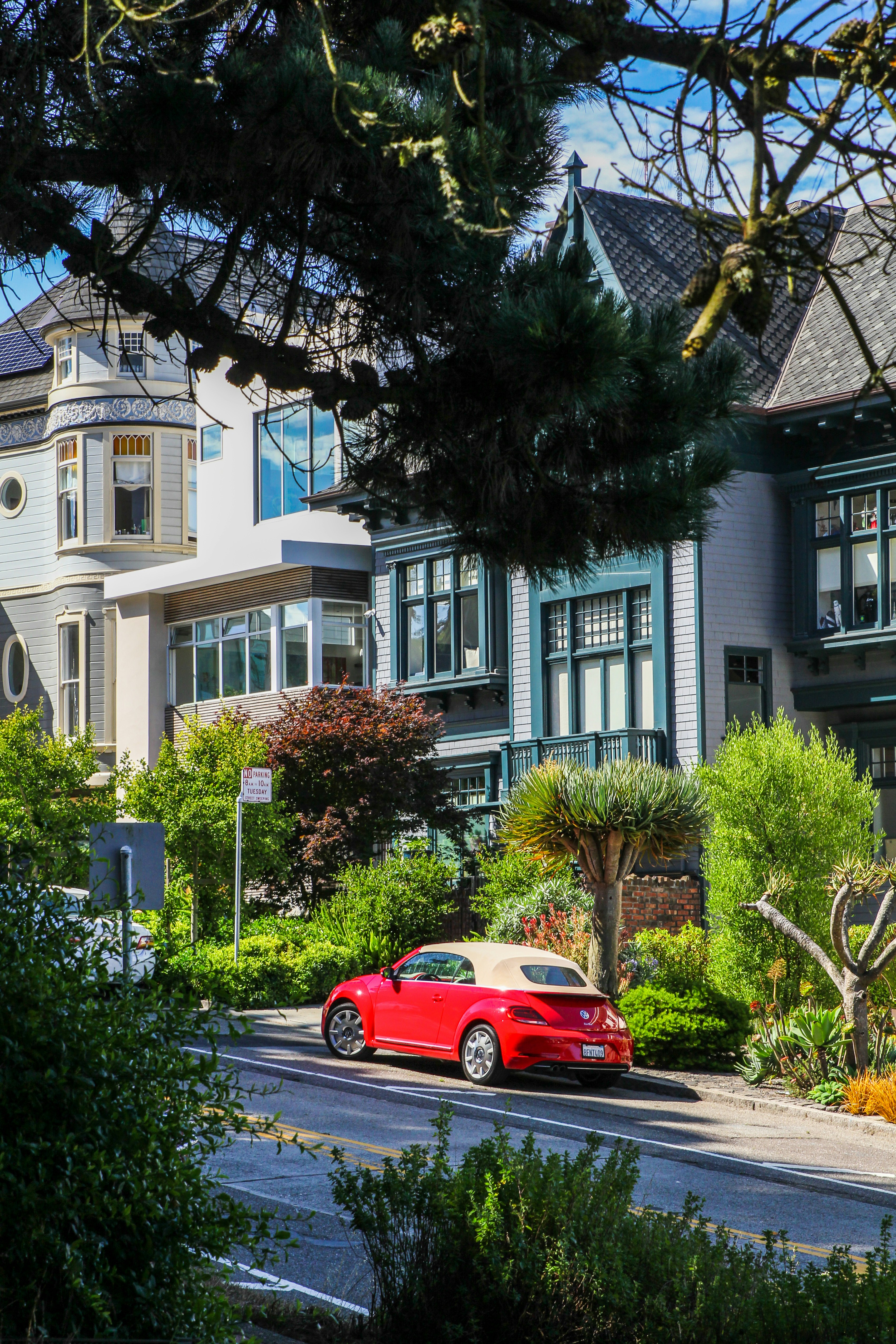 red coupe parking near house during daytime