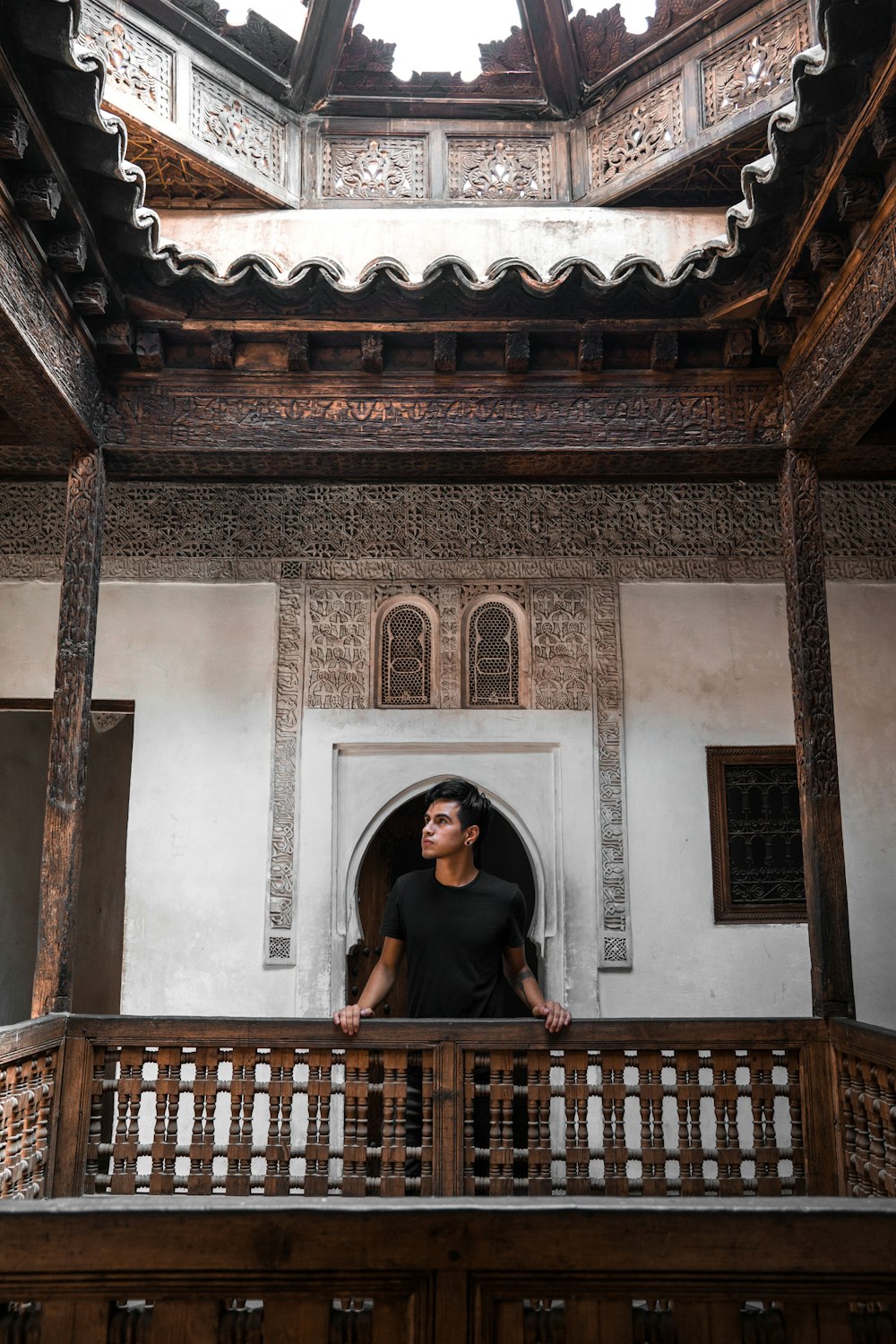 man leaning forward on wooden baluster