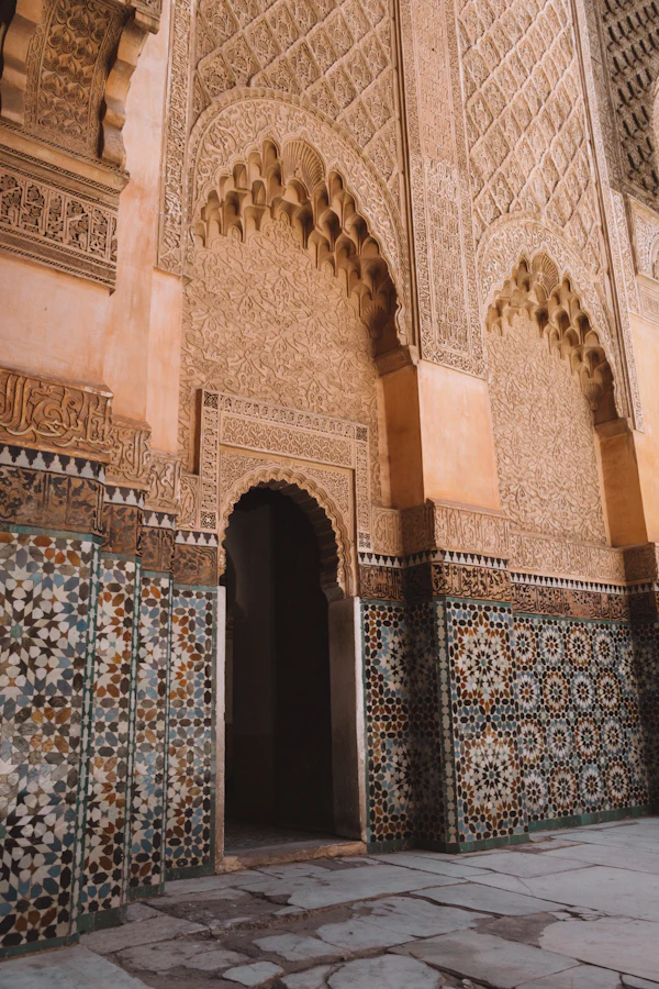 Carved stucco archway and zellige tilework at the Ben Youssef Madrasa in Marrakech