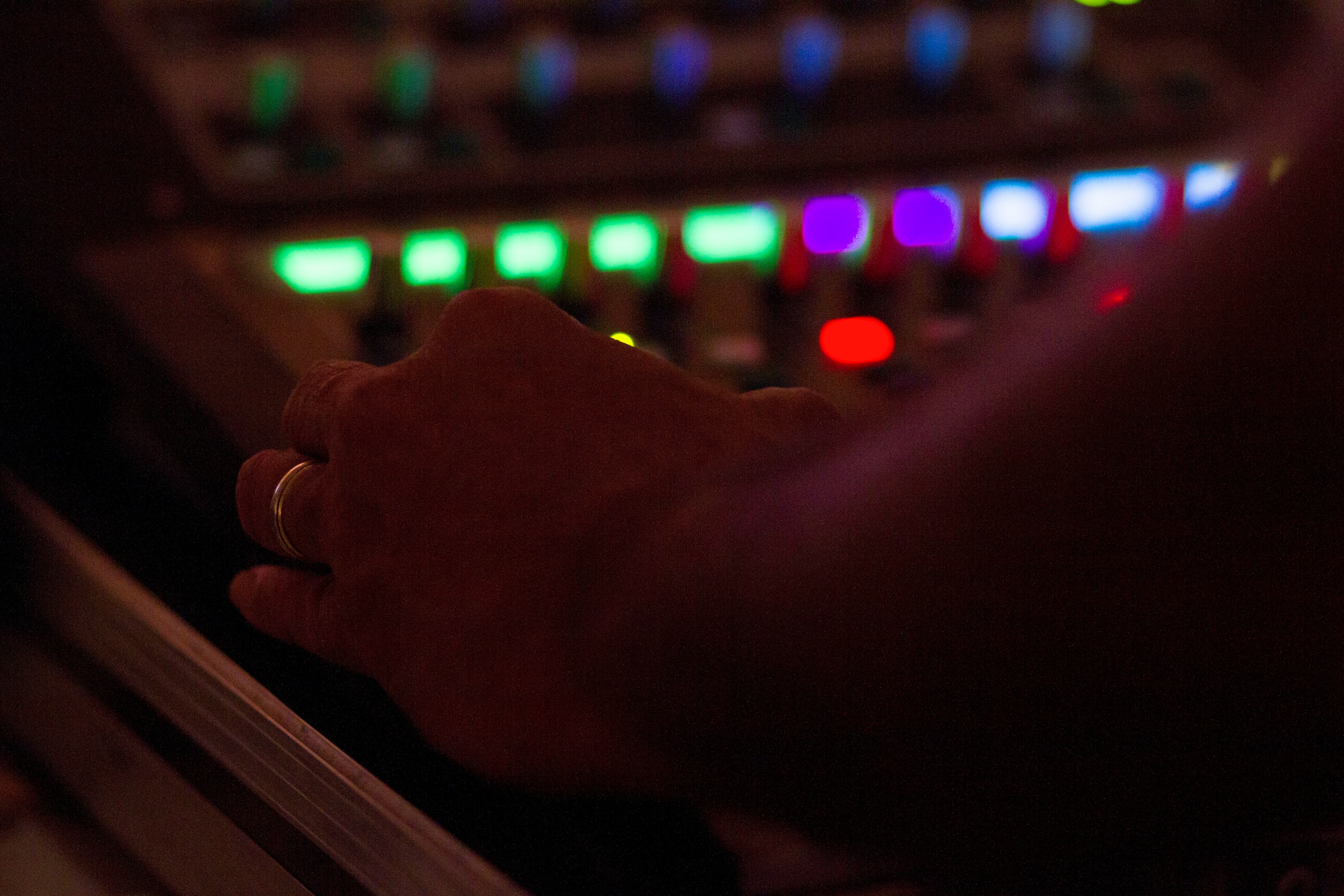 a person's hand in front of a mixing console