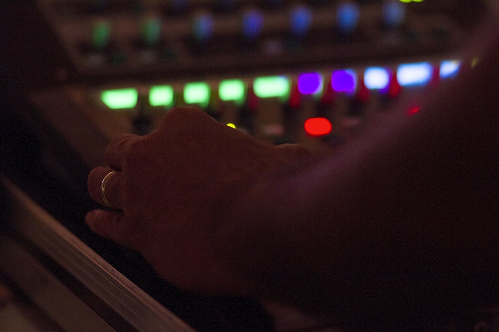 a person's hand in front of a mixing console
