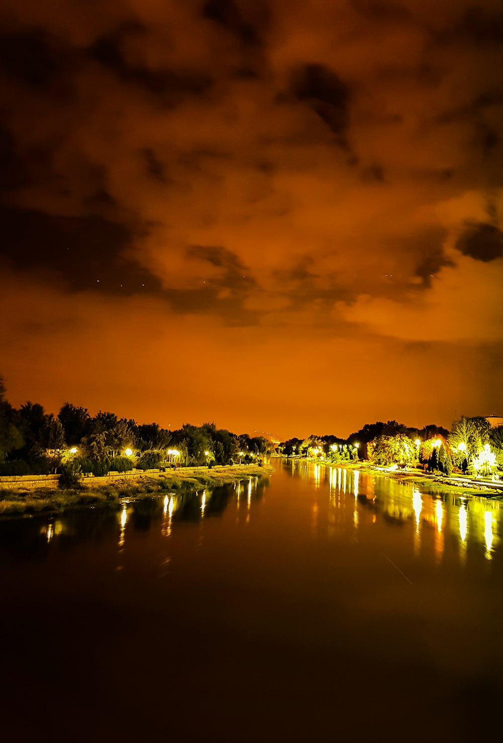 calm body of water between trees at night