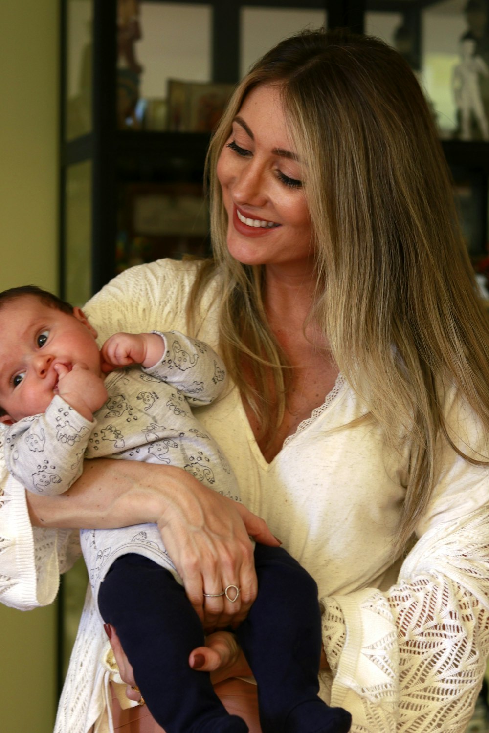 smiling woman standing while carrying newborn baby