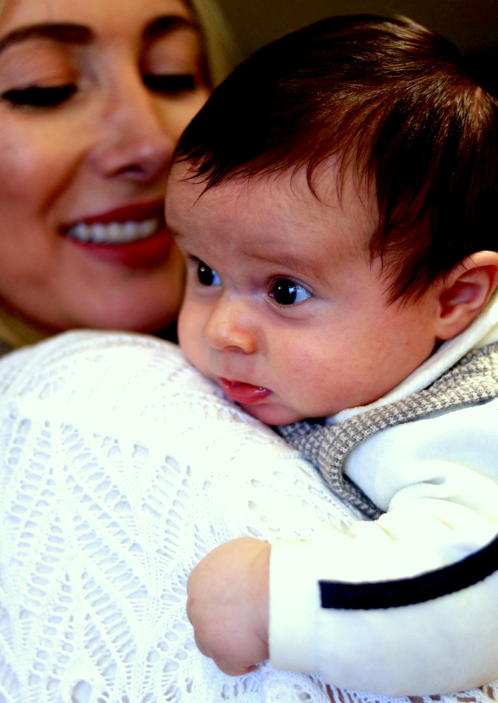 smiling woman carrying newborn baby