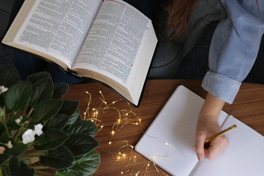 person writing on notebook