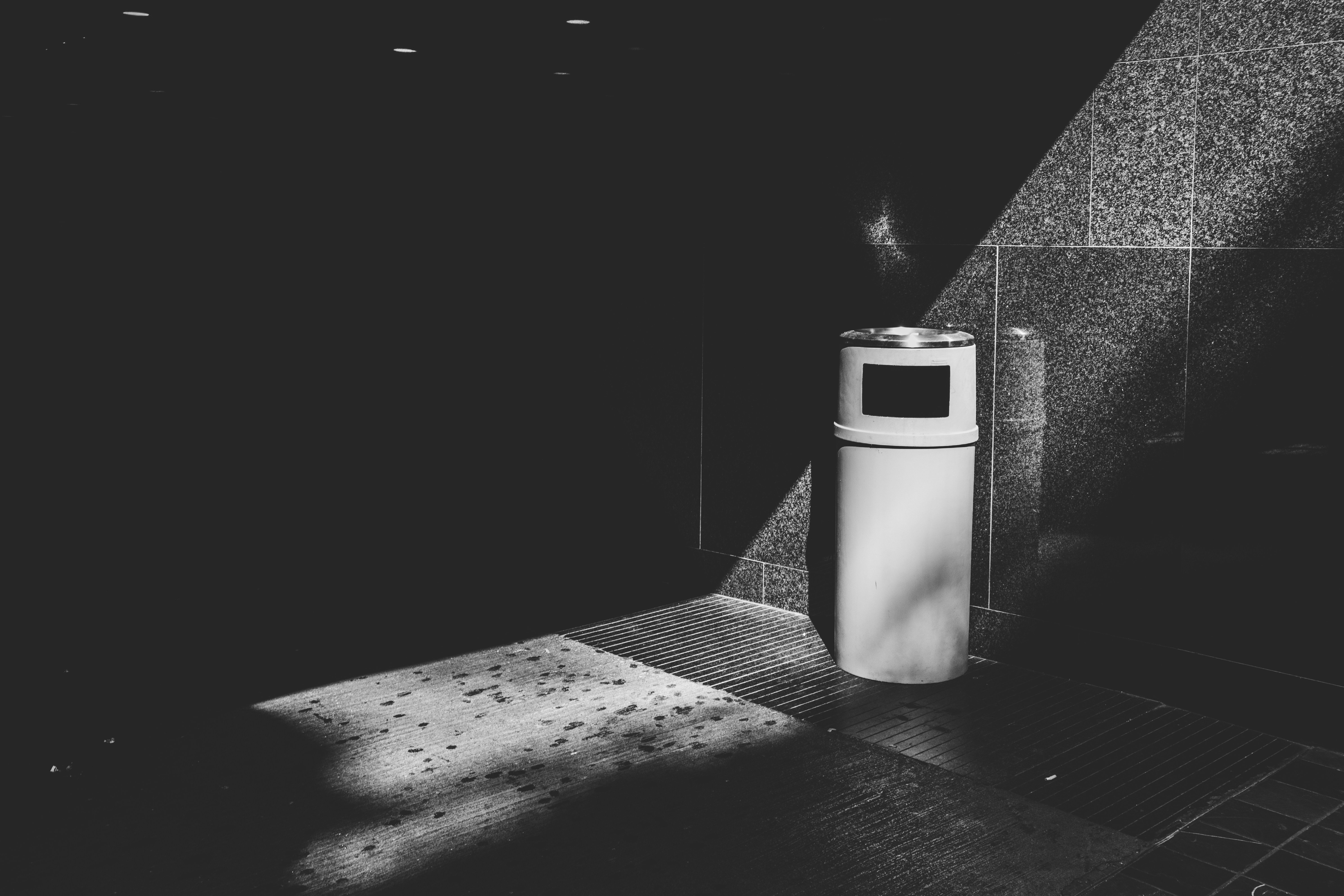 grayscale photo of a trash bin