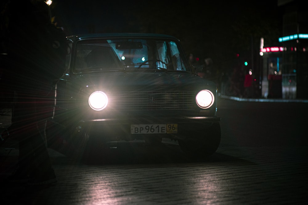 a car driving down a street at night