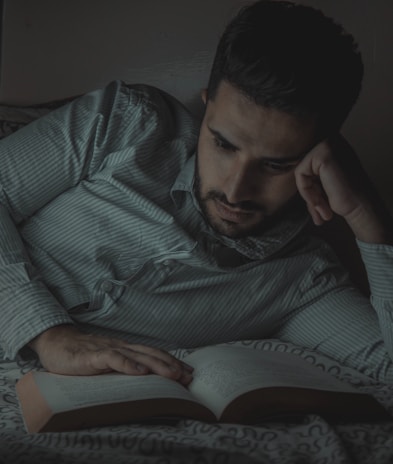 A confident man reading an ebook about sexual health in a cozy, modern room.