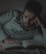 A man relaxing in bed with the sleepsmarter e-book beside him.
