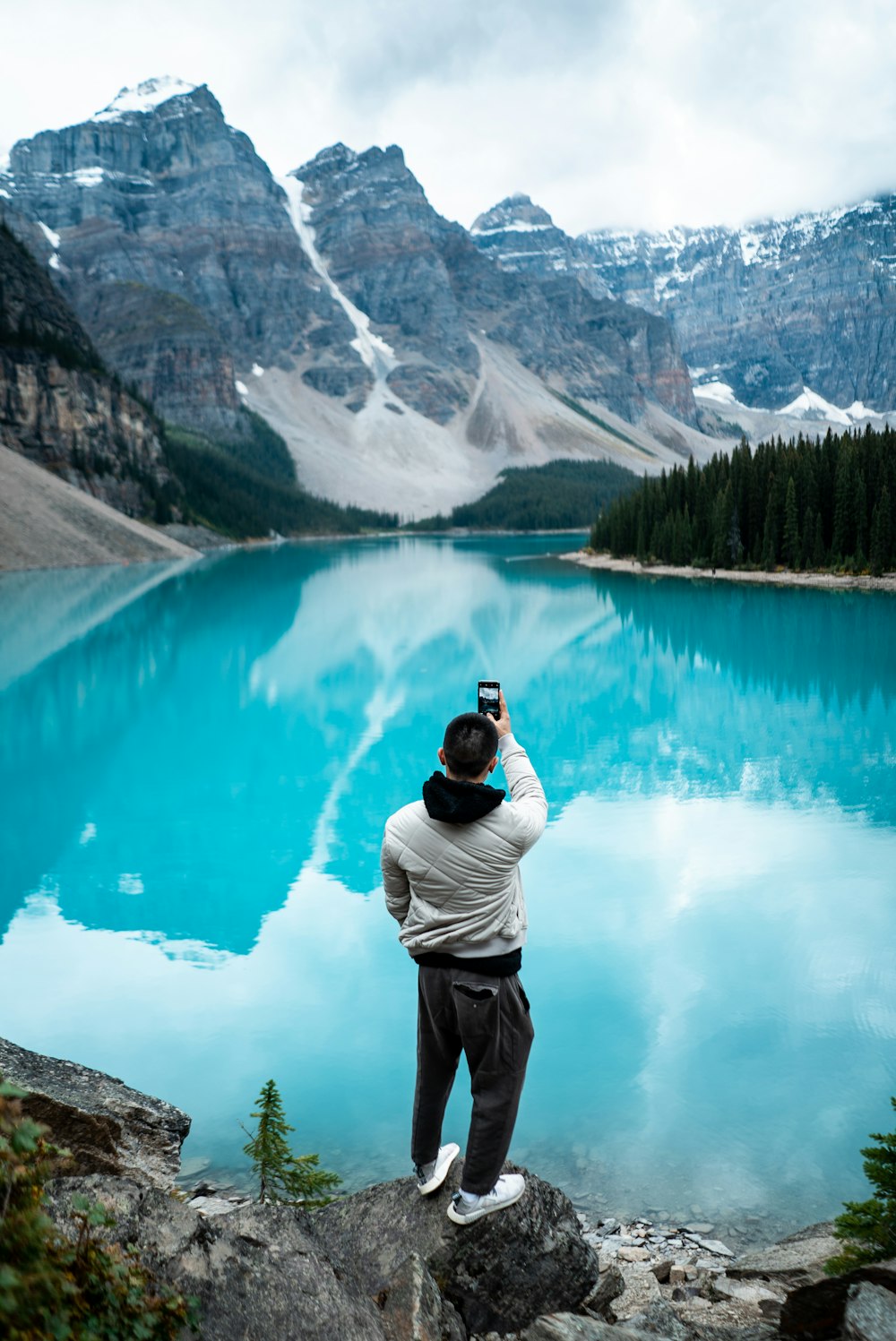 Mann, der tagsüber auf dem Moraine Lake steht