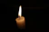 Close-up of a Flambeau candle flame flickering against a cream background.