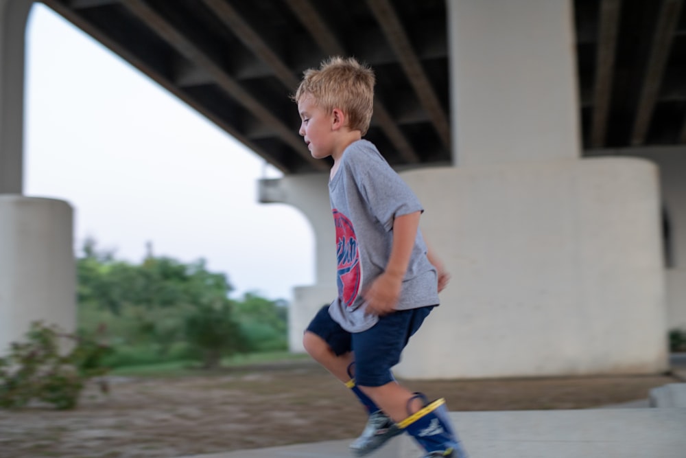 boy in grey crew-neck t-shirt playing outside