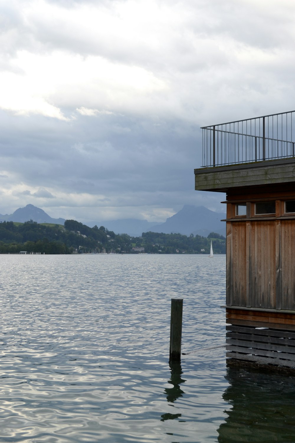 black pole on body of water beside brown building