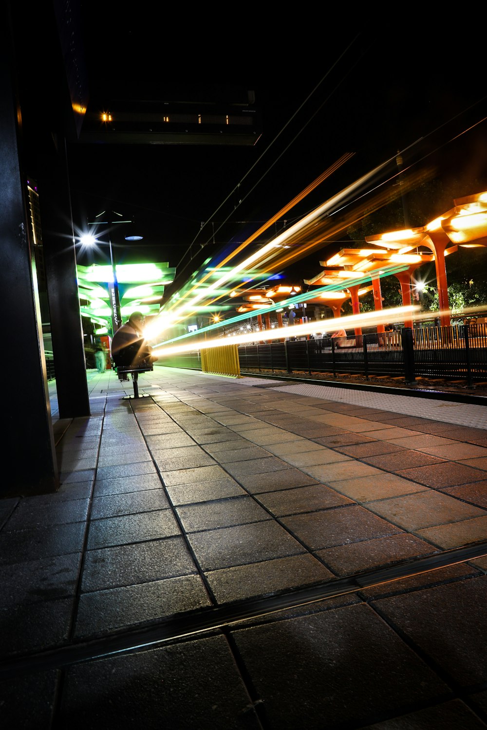 a person walking down a sidewalk at night