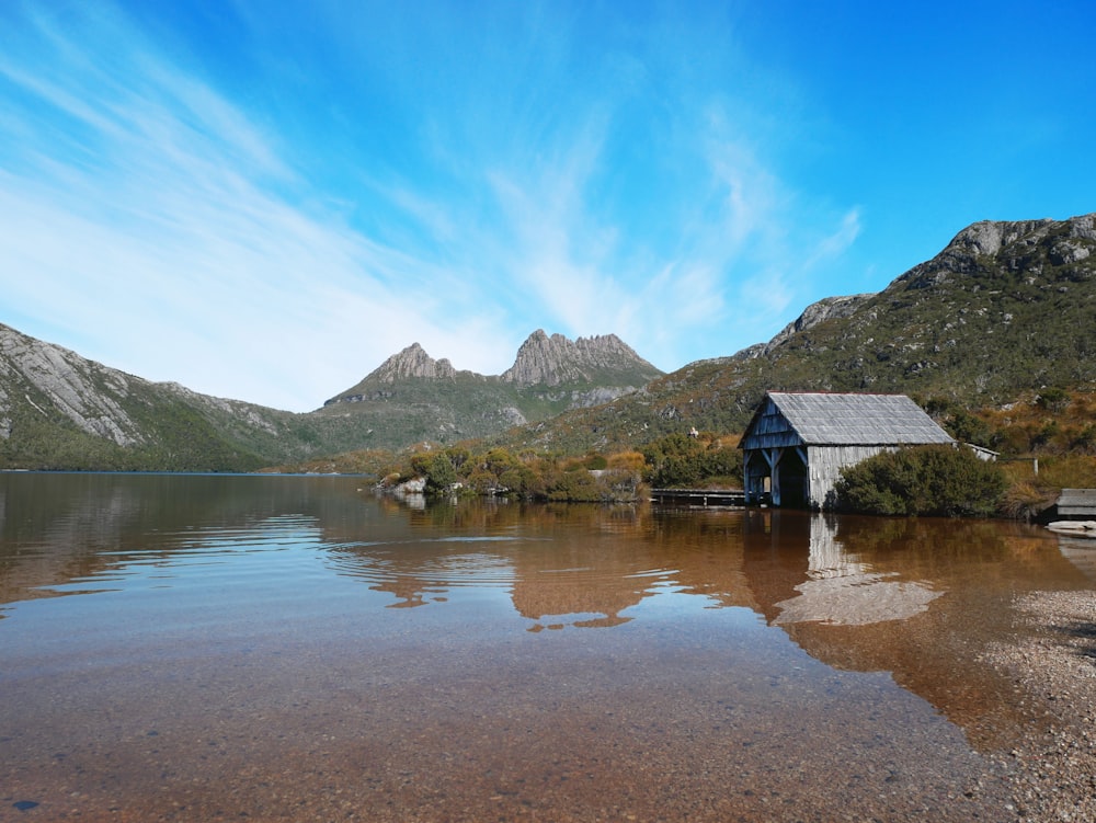 body of water across mountain during daytime