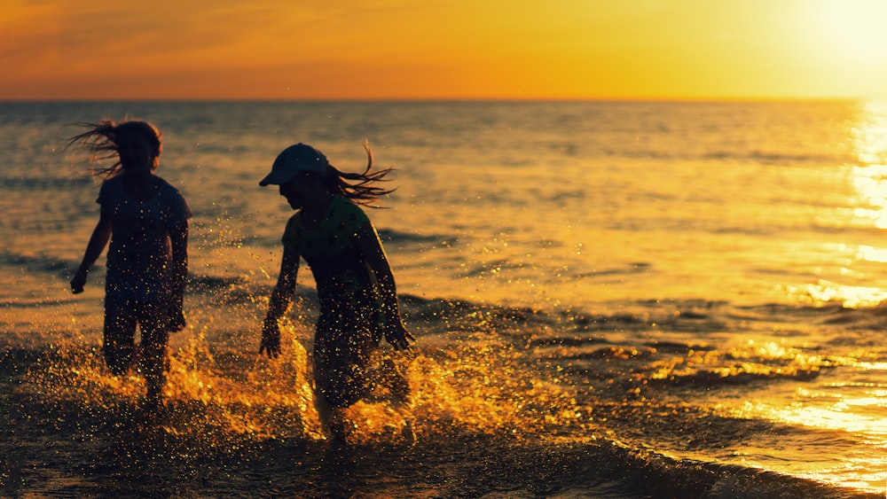 海岸を走る女の子のシルエット写真