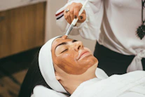 woman receiving facial mask treatment at spa