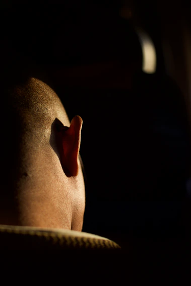 Close-up of a sharp skin fade with clean lines under dramatic lighting.