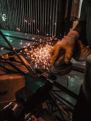 person grinding metal using angle grinder