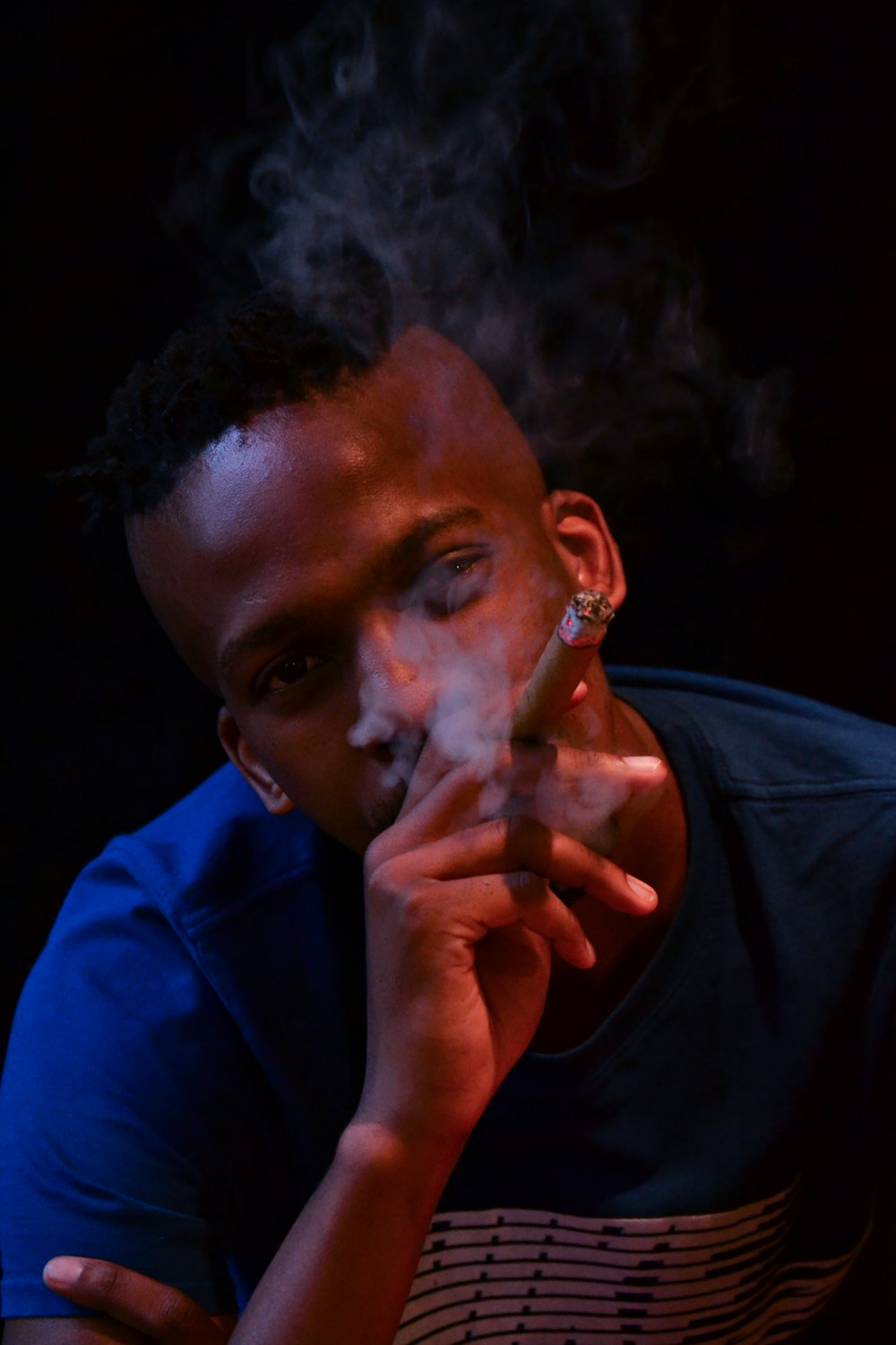 shallow focus photo of man smoking cigar