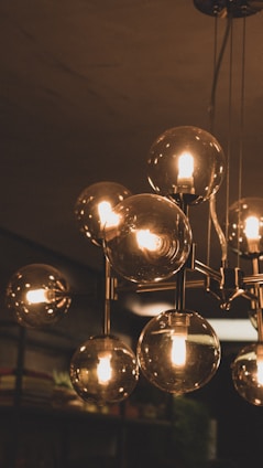 A softly glowing modern chandelier illuminating a cozy living room with warm light.