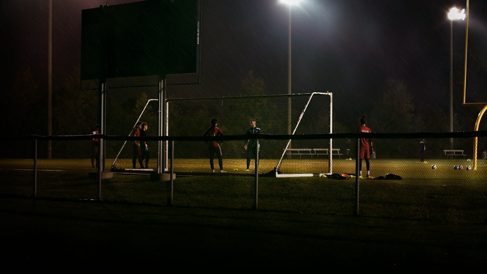 men plays soccer during nighttime