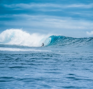 man surfing on sea waves during daytime