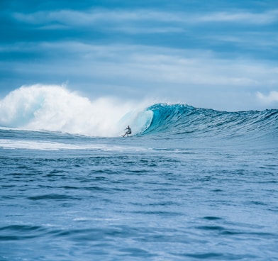 man surfing on sea waves during daytime