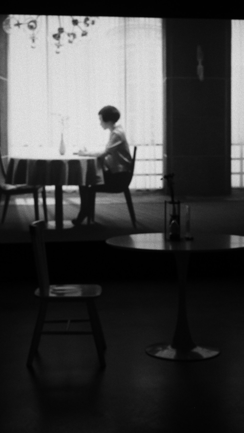 greyscale photography of round wooden table and chair