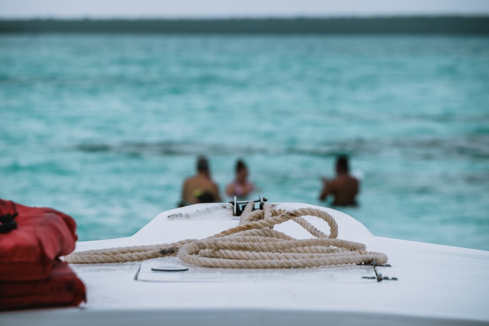 three person in the seawater near boat