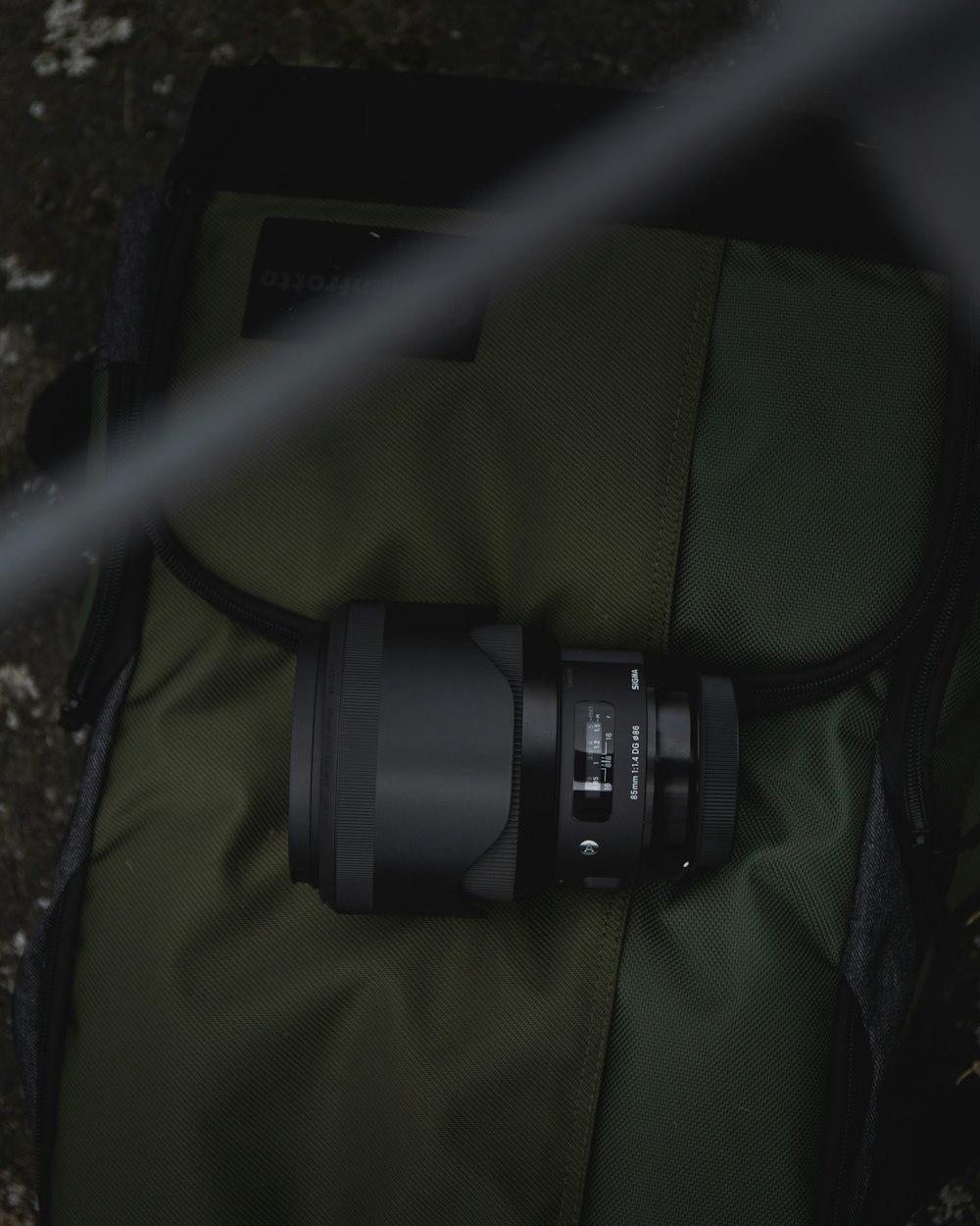 camera lens on olive green backpack